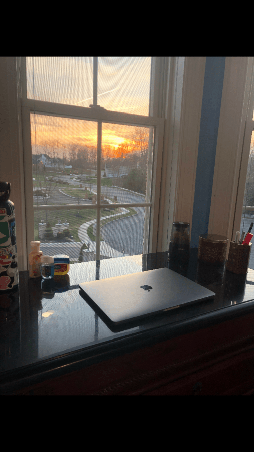 Mehak Dhaliwal's workspace, with her laptop, pencil sharpener, and view of a beautiful sunset.